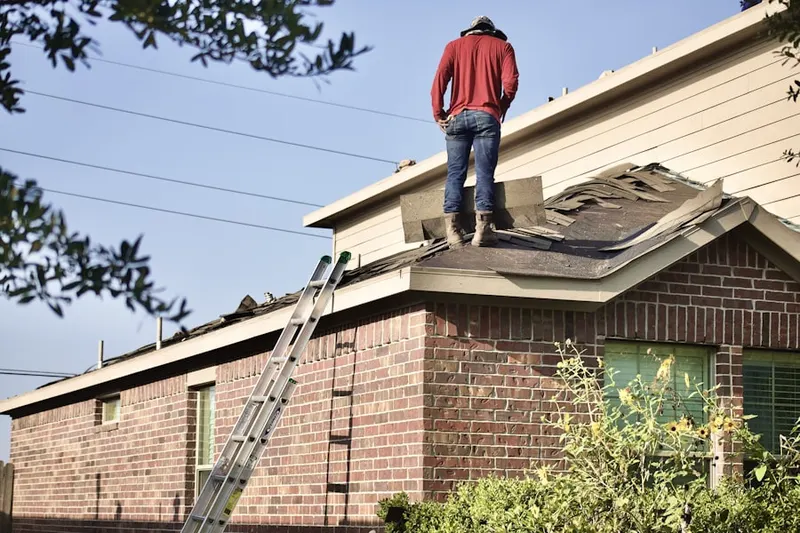 Professional roofer working on a residential roof in Dozier